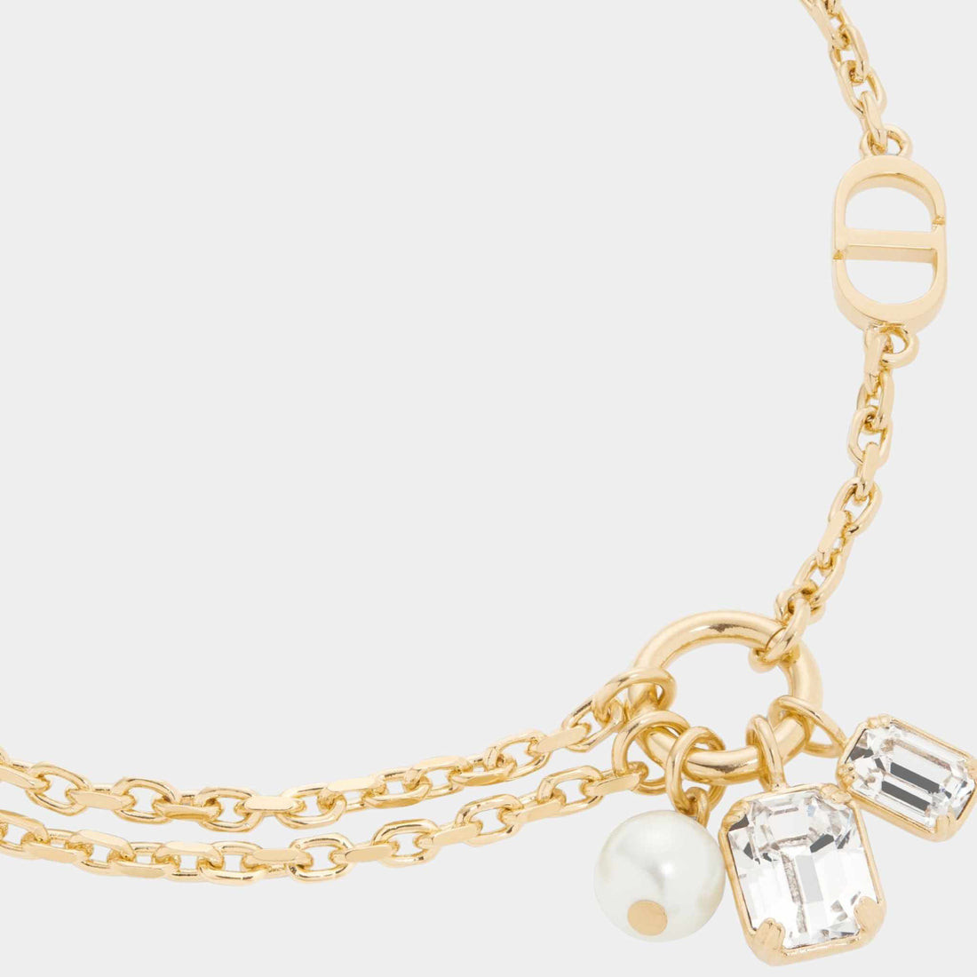 Dior Petit CD سوار من معدن بلمسة نهائية ذهبية مع لؤلؤة من الراتنج الأبيض وكريستالات بلون الفضة، عن قرب